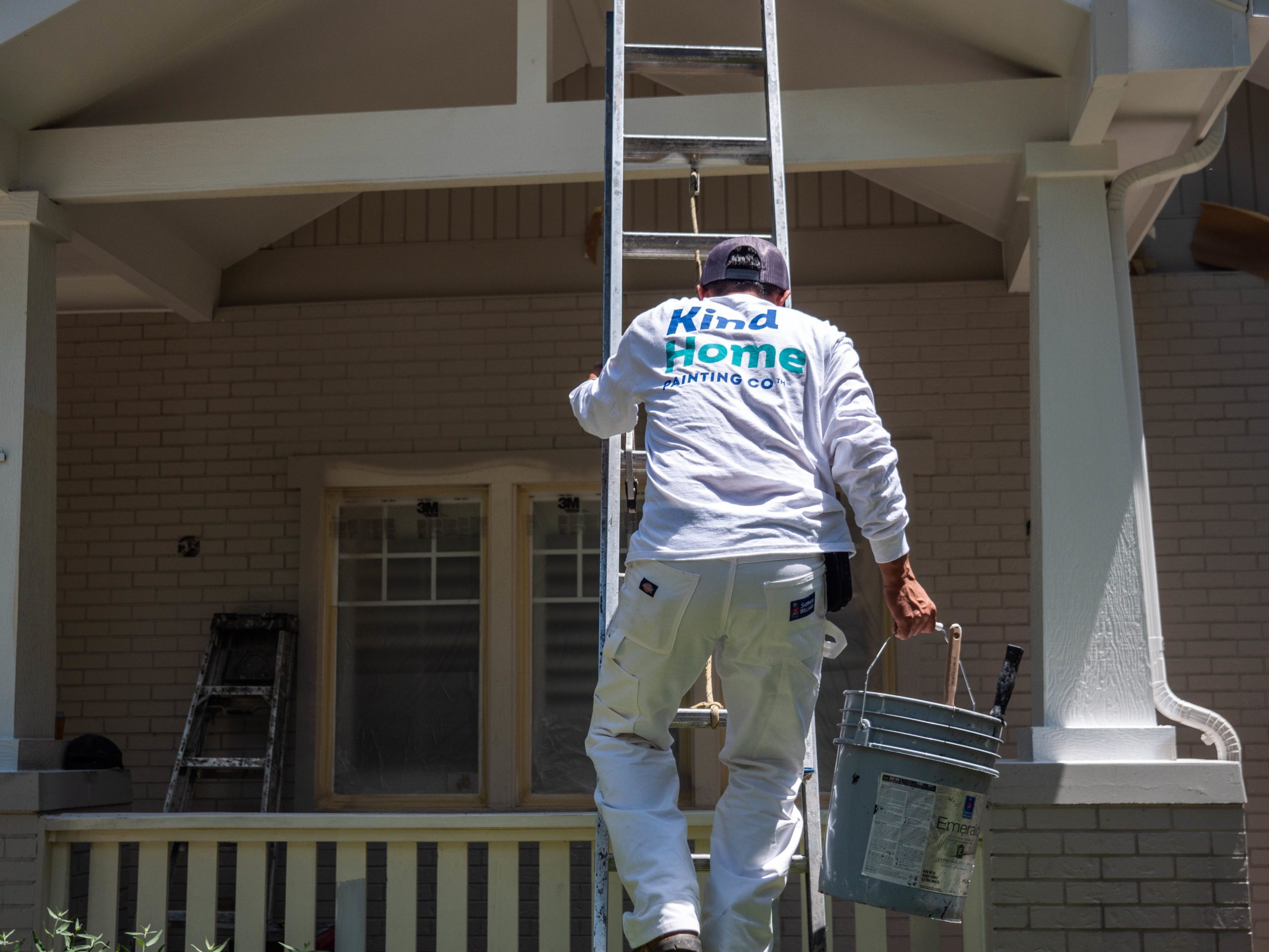 photo of a kind home painter climbing down a ladder