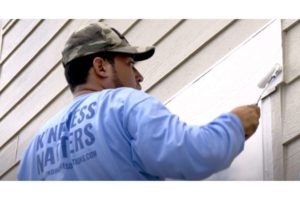 photo of painter rolling the exterior of a home