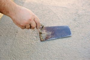 photo of someone repair stucco and smoothing it over
